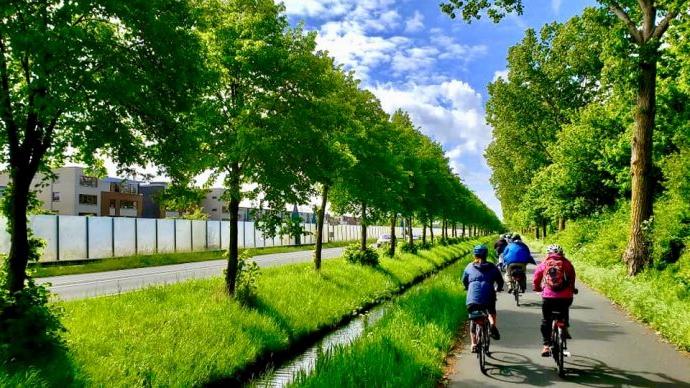 Transylvania students riding bikes on a tree-lined trail